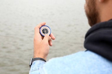 Nehir kenarında pusulası olan adam, yaklaş.