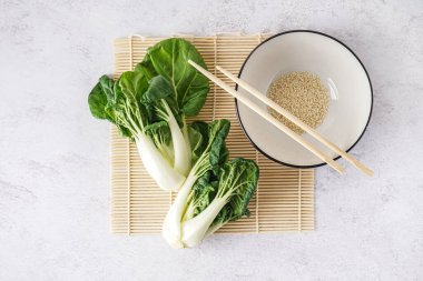 Taze pak choi lahanası ve arka planda susam tohumları.