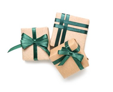 Beyaz arkaplanda yeşil kurdeleyle bağlanmış hediye kutuları