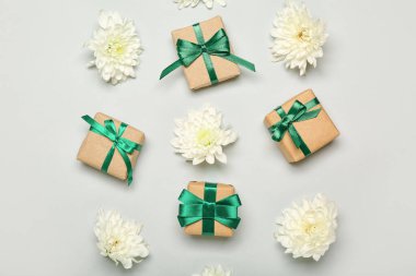 Beyaz arka planda hediye kutuları ve güzel kasımpatı çiçekleri olan kompozisyon