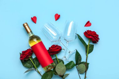 Bir şişe şarap, mavi arka planda güller ve kalpler. Sevgililer Günü kutlaması