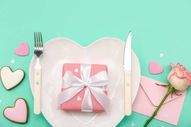 Sevgililer Günü için hediye, zarf ve yeşil arka planda gül.