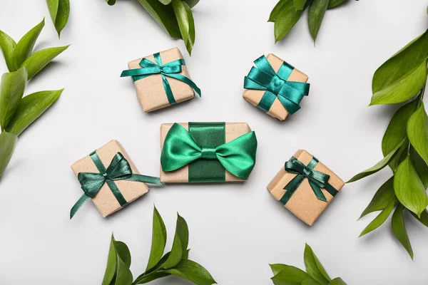 Composition with beautiful gifts and plant branches on white background
