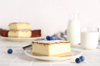 Açık arkaplanda yaban mersinli peynirli turta.