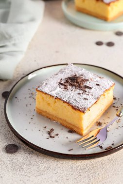 Tabak peynirli turta ve çatal beyaz masada.