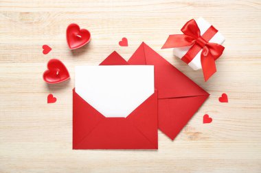 Mumlarla dolu boş bir mektup, hediye ve ahşap arka planda kalpler. Sevgililer Günü kutlaması