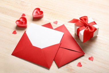 Mumlarla dolu boş bir mektup, hediye ve ahşap arka planda kalpler. Sevgililer Günü kutlaması