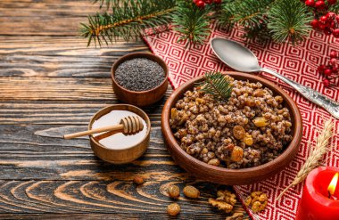 Bir kase Kutya, malzemeler ve koyu ahşap arka planda Noel dalları.