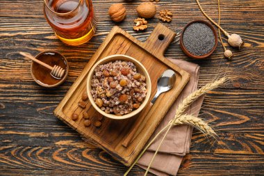 Koyu ahşap arka planda malzemeler ve çivili Kutya kasesi.