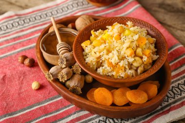 Tepside bir kase pirinç Kutya, malzemeler ve peçetenin üzerindeki haşhaş kapsülleri, yakın plan.