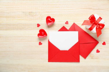 Mumlarla dolu boş bir mektup, hediye ve ahşap arka planda kalpler. Sevgililer Günü kutlaması