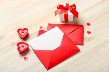 Mumlarla dolu boş bir mektup, hediye ve ahşap arka planda kalpler. Sevgililer Günü kutlaması