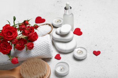 Sevgililer Günü için güzel bir spa kompozisyonu. Taşlar, çiçekler, fırça, mumlar ve hafif arka planda kalpler.
