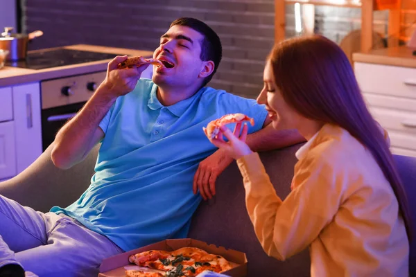 Young Man Eating Tasty Pizza His Girlfriend Sofa Kitchen Night — Stock Photo, Image