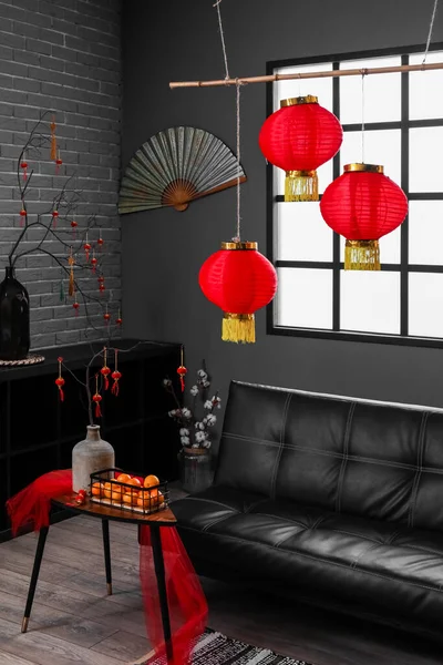 Interior of dark living room with couch, table and decor for Chinese New Year celebration