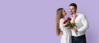 Leylak arka planında çiçek buketi olan mutlu genç bir çift ve mesaj için yeri var. Sevgililer Günü kutlaması