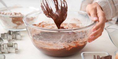 Mutfak masasında çikolata hamuru hazırlayan kadın, yakın plan.