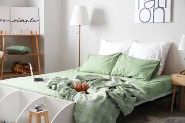 Büyük rahat yataklı ve sonbahar dekorlu modern bir oda.