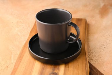 Siyah plakalı ahşap tahta ve grunge bej arka planda fincan.