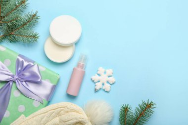 Kozmetik ürünleri, Noel hediyesi ve renk arkaplan üzerine köknar dalları içeren kompozisyon