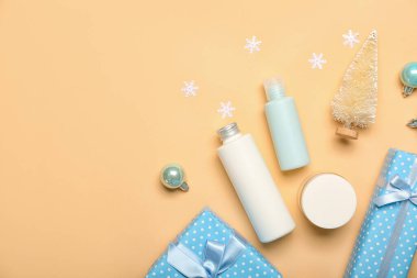 Kozmetik ürünleri, Noel hediyeleri ve renk arkaplanındaki dekorasyonlarla kompozisyon