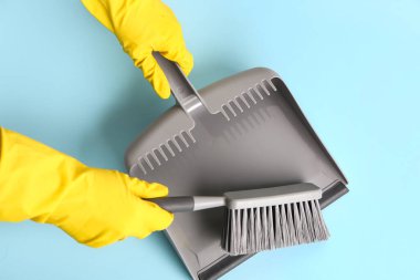 Faraş ve fırçayla kaplanmış lastik eldivenli kadın elleri, yakın plan.