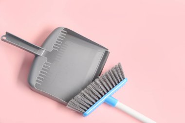 Pembe arka planda süpürge ve faraş temizleme