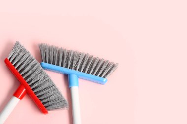 Pembe arka planda temizlik süpürgeleri