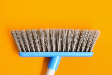 Renk arkaplanında temizlik için süpürge, kapat