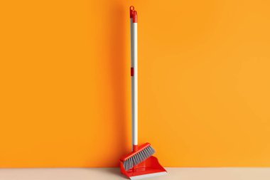 Renkli duvarın yanında temizlik süpürgesi olan faraş.