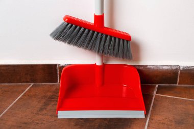 Duvarın yanında süpürgesi olan faraş.