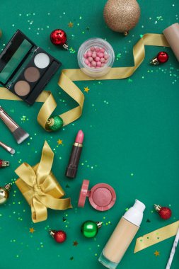 Kozmetik ürünleri, Noel süslemeleri ve renk arkaplanı üzerine kurdele