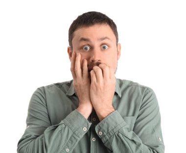 Gömlekli yakışıklı adam beyaz arka planda tırnak yiyor, yakın plan.