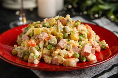 Koyu arkaplanda lezzetli Olivier salatası, yakın plan.