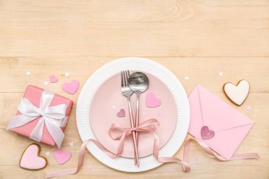 Sevgililer Günü için masa ayarlayın. Tahta arka planda hediyeler, zarf ve kalpler olsun.