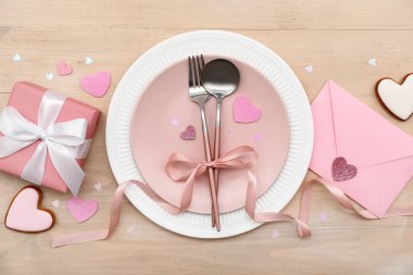 Sevgililer Günü için masa ayarlayın. Tahta arka planda hediyeler, zarf ve kalpler olsun.