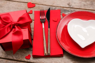 Sevgililer Günü için masa ayarları, hediye ve ahşap arka planda kalpler, yakın plan.