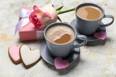 Kurabiyeli latte, hediye ve arkaplanda gül. Sevgililer Günü kutlaması