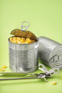 Mısır taneli teneke kutular ve yeşil arka planda açacağı.
