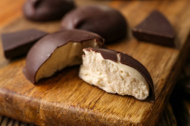 Lezzetli kuş sütlü şekerlemelerle tahtayı kesme, yakın plan.