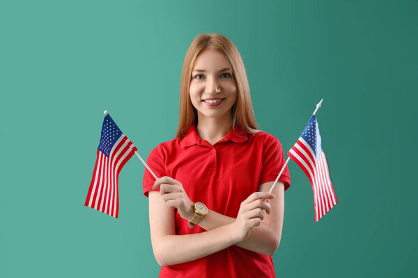 Young redhead woman with USA flags on green background