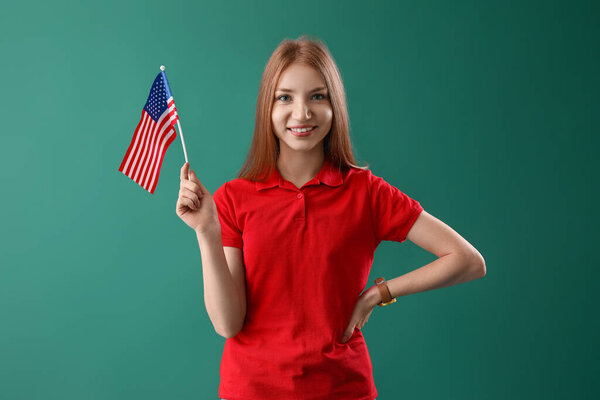Young redhead woman with USA flag on green background