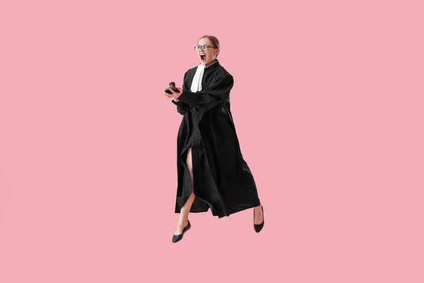Злая Женщина Судья Молотком Прыгает Розовом Фоне — стоковое фото