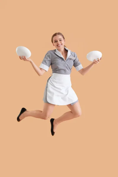 Young Waitress Plates Jumping Beige Background — Stock Photo, Image