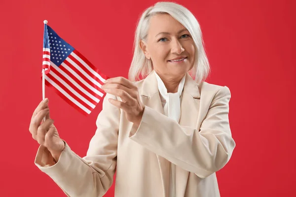 Mature woman with USA flag on red background