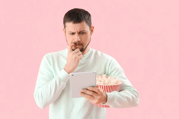 Handsome Man Tablet Computer Popcorn Biting Nails Pink Background — Stock Photo, Image