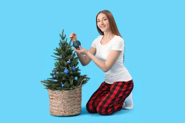 Jovem Pijama Decorando Pequena Árvore Natal Fundo Azul — Fotografia de Stock