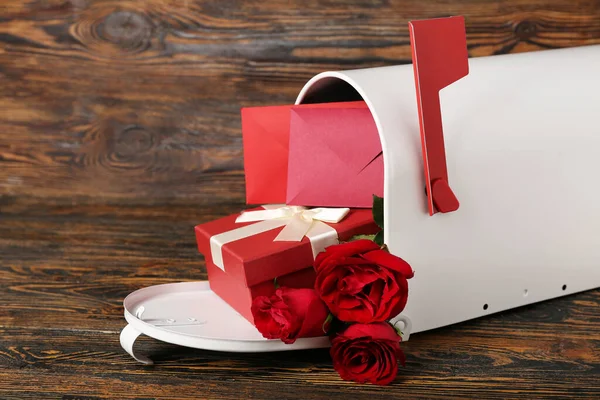 Mailbox with letters, roses and gift on wooden background. Valentine\'s Day celebration