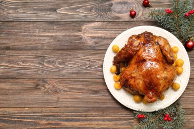 Lezzetli fırında tavuk, köknar dalları ve ahşap arka planda Noel süslemeleri içeren kompozisyon