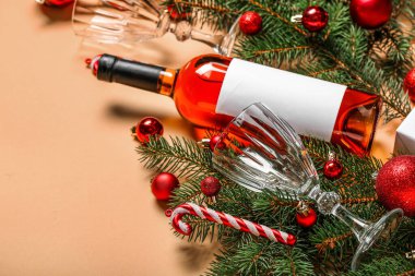 Gözlüklü bir şişe şarap, Noel oyuncakları ve bej arka planda köknar dalları, yakın plan.
